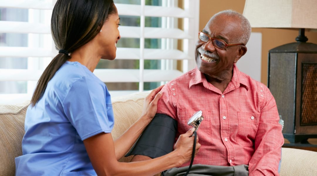 Nurse Visiting Senior Male Patient At Home